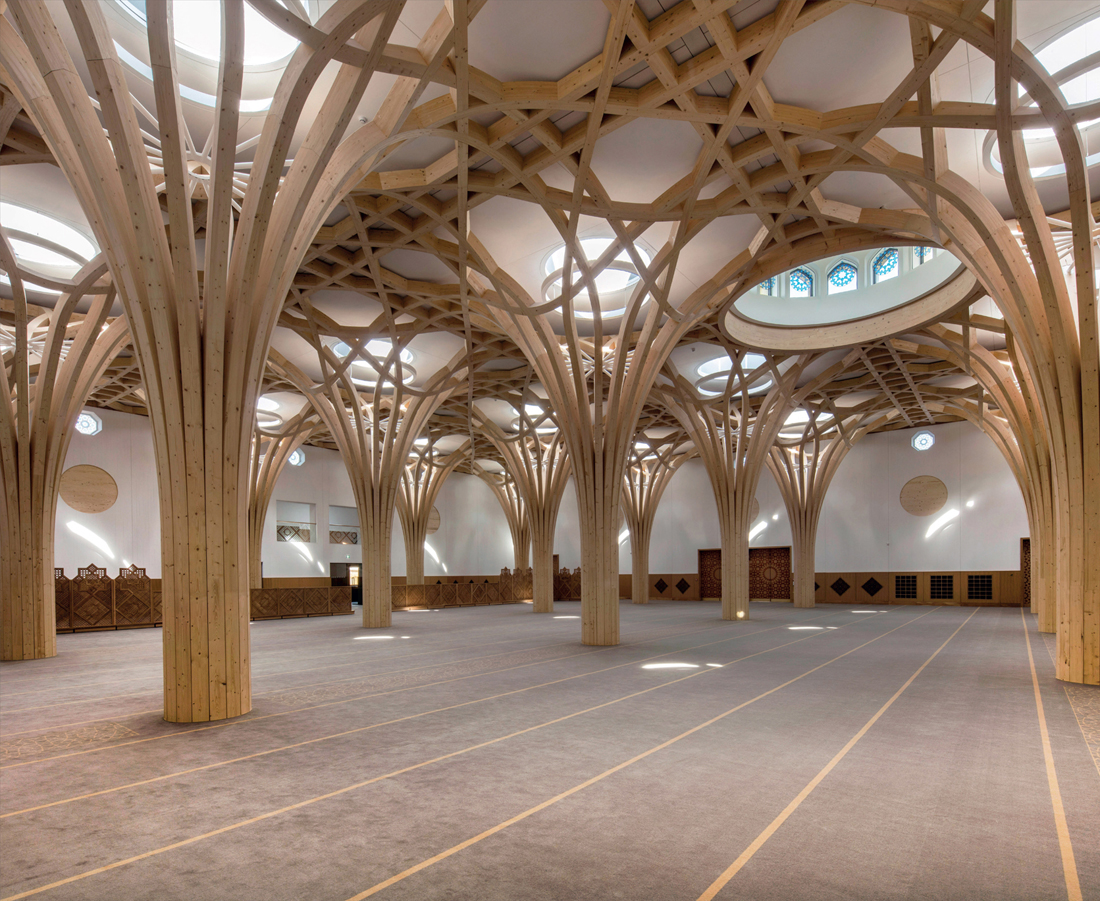 FIG 5.0 (chapter opener) The main prayer hall of Cambridge Mosque by Marks Barfield (2019), with white painted CLT wall and roof enclosure beyond tree form glulam structures.