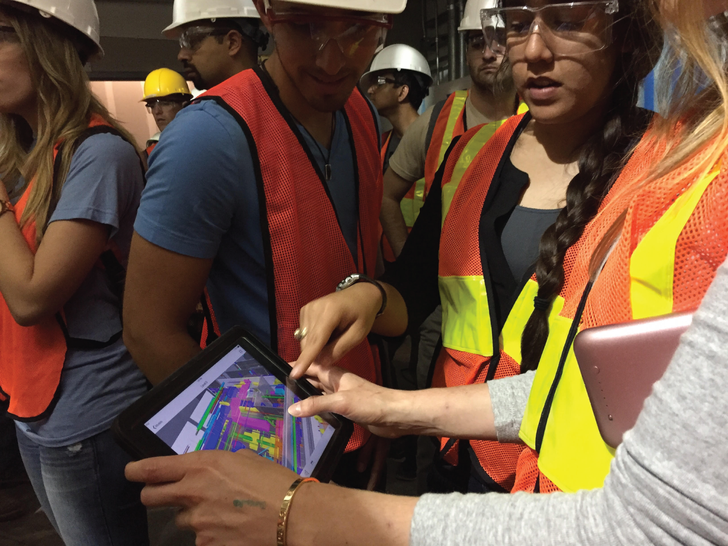 Photograph of a team of workers discussing how to access a coordinated model in the field via a tablet computer.