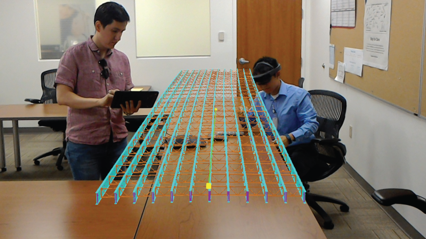 Photograph depicting field engineers using augmented reality for the design review of a project.