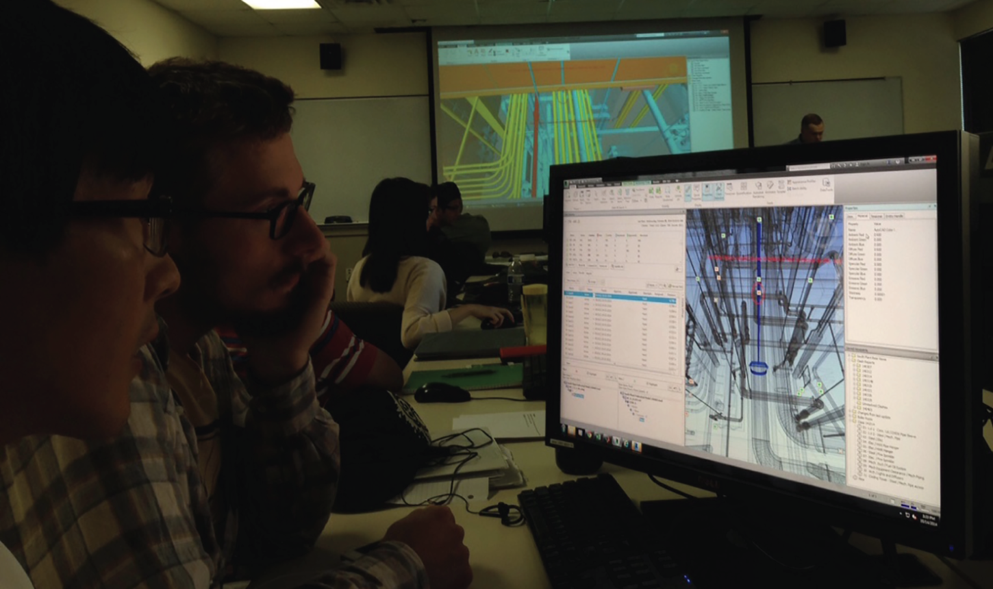 Photograph depicting groups of university students in front of desktop computers discussing construction projects.